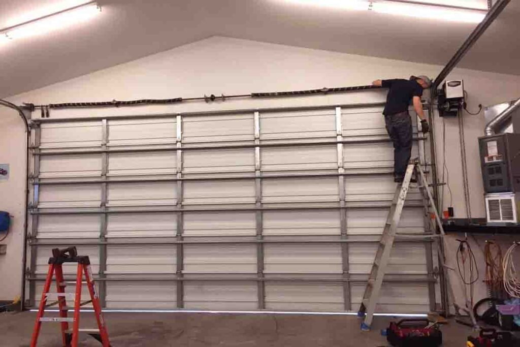 Technician repairing a large commercial garage door