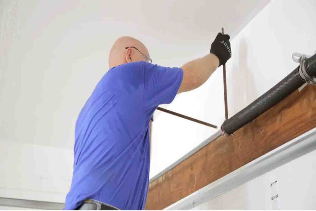 Technician replacing a torsion spring using proper tools